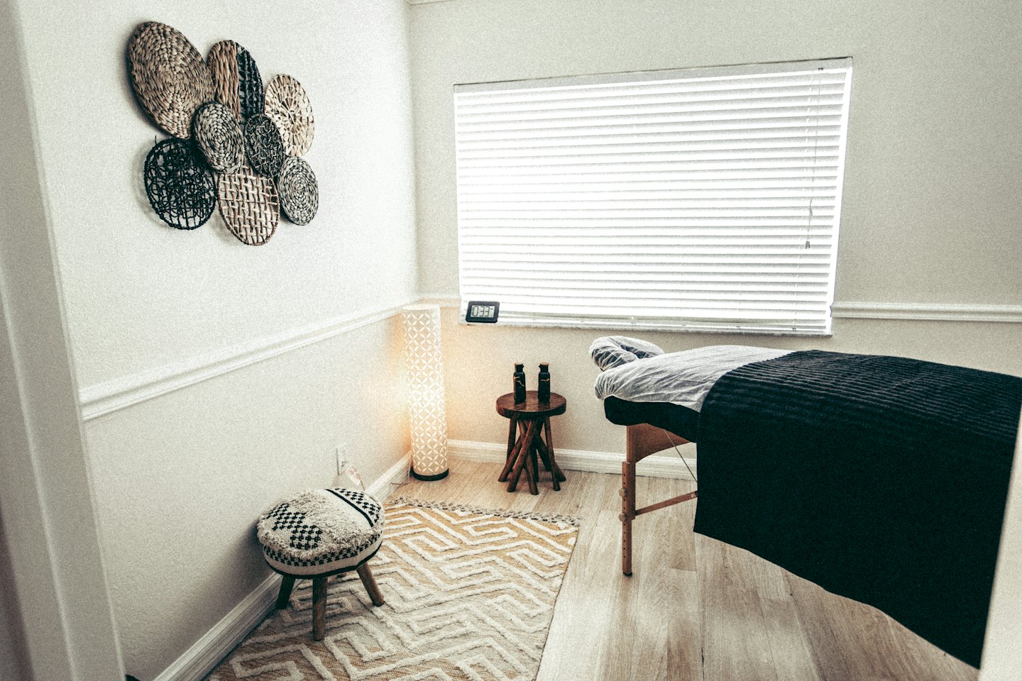 Letto da massaggio vuoto in una stanza terapeutica tranquilla con pavimenti in legno.